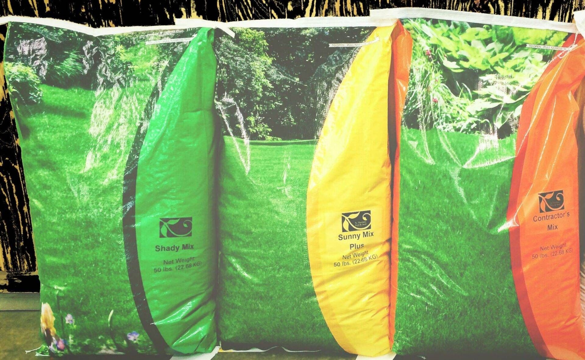 Colorful green, yellow, and orange insulated bags hanging side by side outdoors.