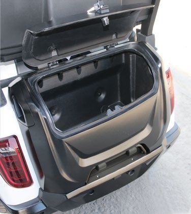 The trunk of a golf cart is open and empty
