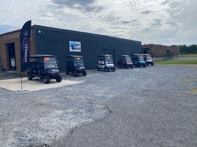 A row of golf carts parked in front of a building.