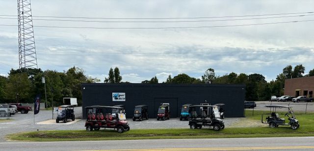 A group of golf carts are parked in front of a building.