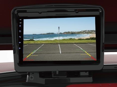 A rear view camera shows a beach and a parking lot