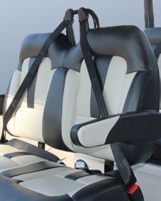 A close up of a black and white golf cart seat with seat belts.