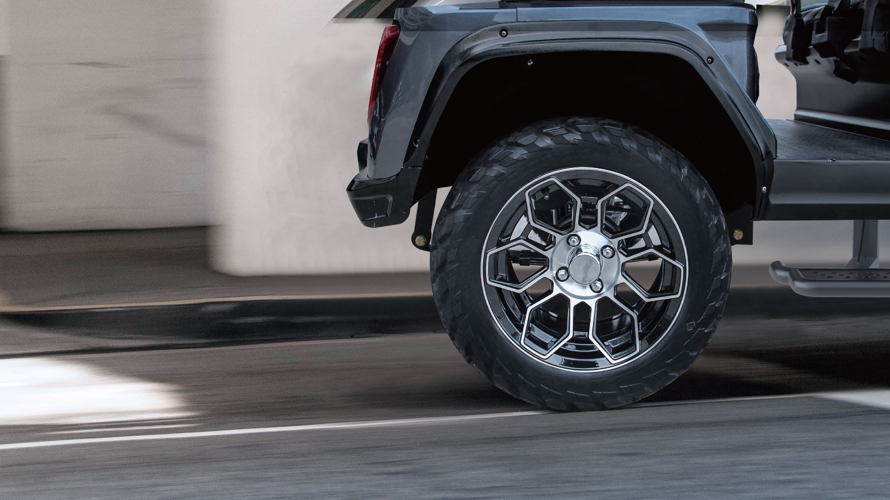 A close up of a truck 's wheel on a street.