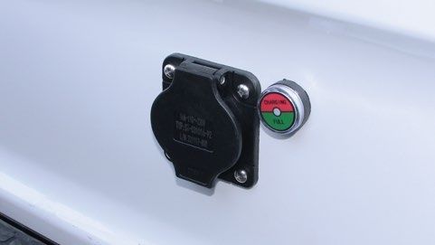 A close up of a plug on the side of a car.