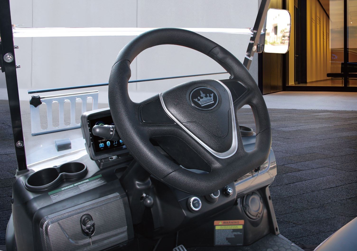 The inside of a golf cart with a steering wheel