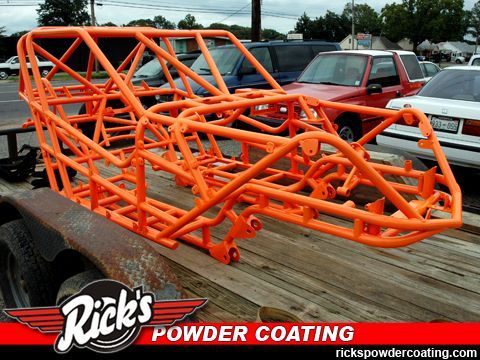 Orange off-road vehicle chassis on a trailer, with Rick’s Powder Coating logo in the corner