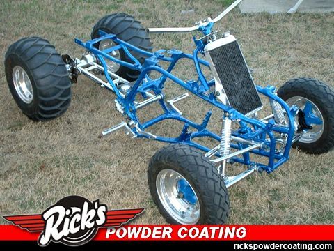 Blue powder-coated off-road buggy chassis with large tires on grass, Rick’s Powder Coating logo in corner