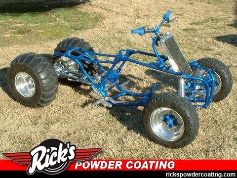 Blue custom dune buggy with oversized rear tires on grass, shown by Rick’s Powder Coating logo