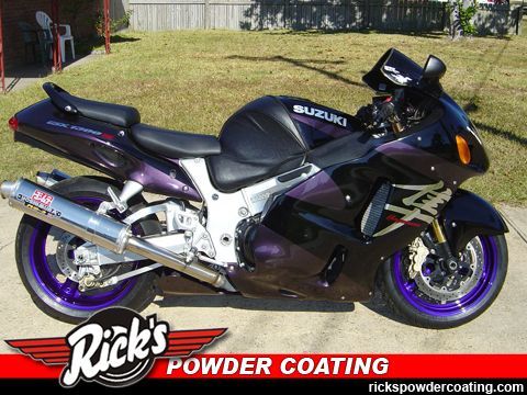 Black Suzuki sport motorcycle with purple wheels parked on grass, showing Rick’s Powder Coating logo.
