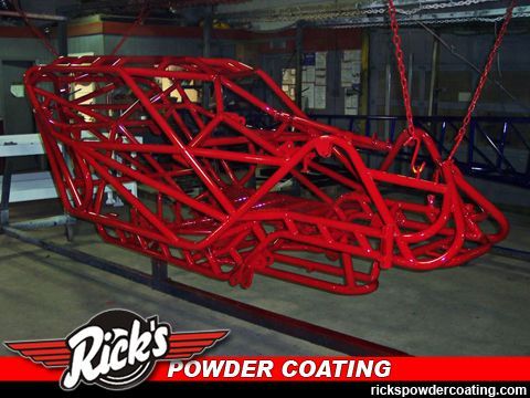 Red powder-coated roll cage frame in an industrial workshop, with Rick’s Powder Coating logo.