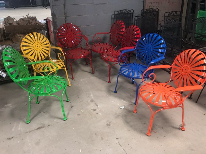 Colorful metal patio chairs in red, blue, green, yellow, and orange arranged in a storage area.
