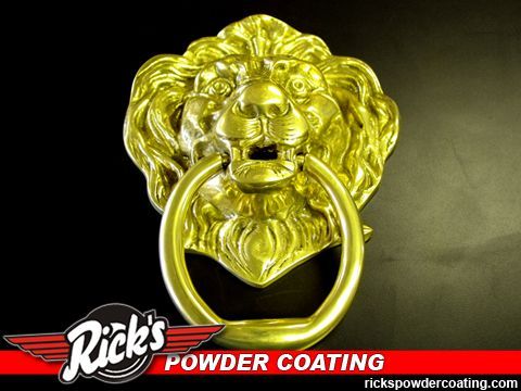 Gold lion-head door knocker on a dark background with Rick’s Powder Coating logo