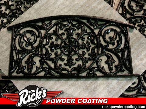 Black wrought-iron decorative railing panel with ornate scrollwork on a light background