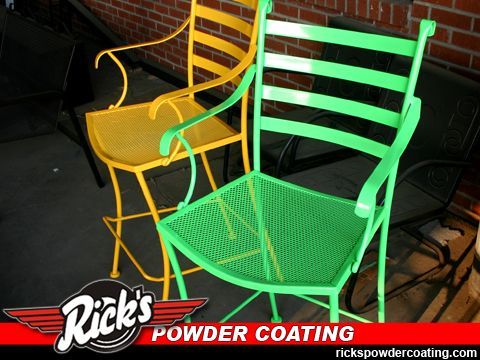 Two bright powder-coated metal chairs, one yellow and one green, on a dark floor with Rick's Powder Coating logo.