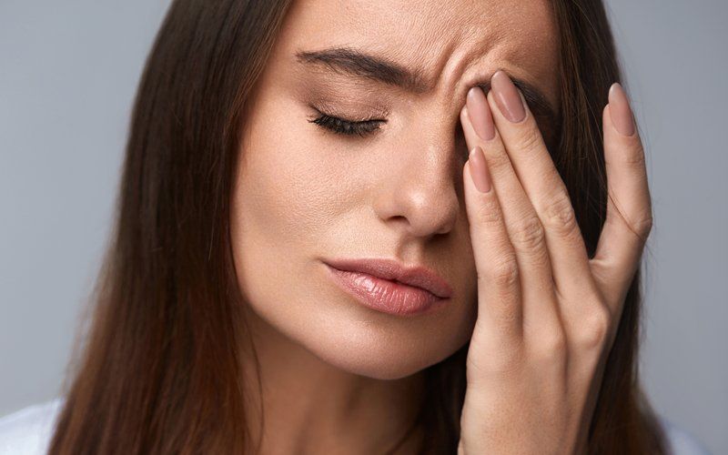 Woman suffering intense pain due to eye disease