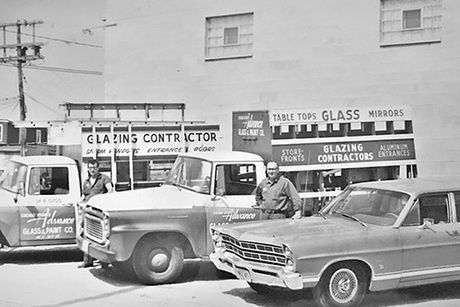 Old photo of storefront and service cars