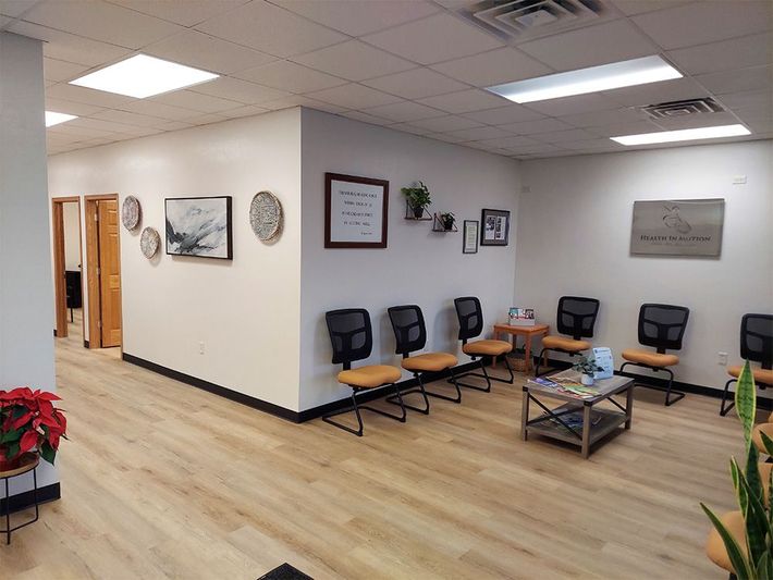 A waiting room with a lot of chairs and a coffee table