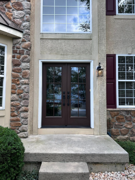The front door of a house with a stone wall and a nice door.