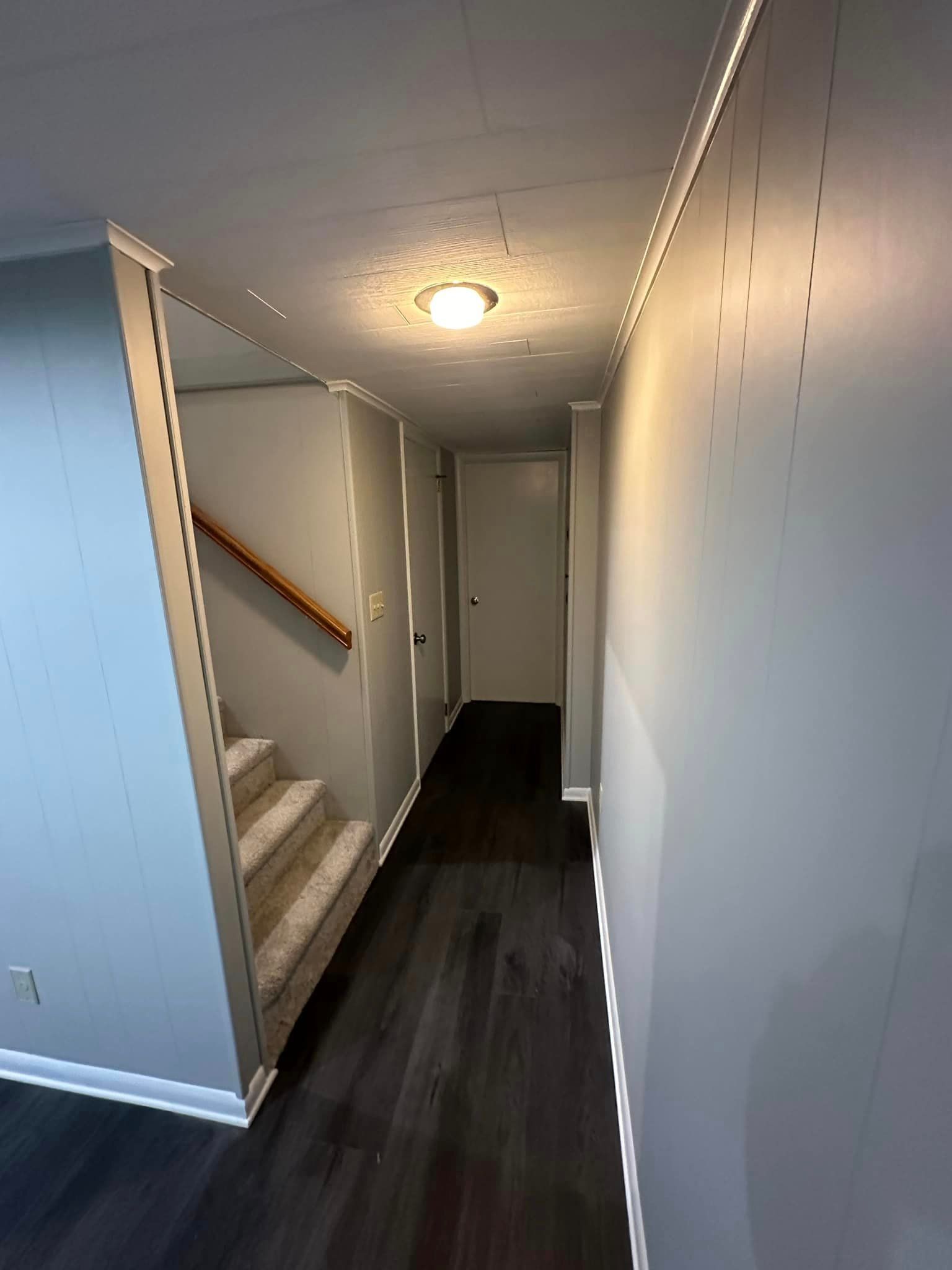 A hallway with stairs leading up to the second floor of a house.