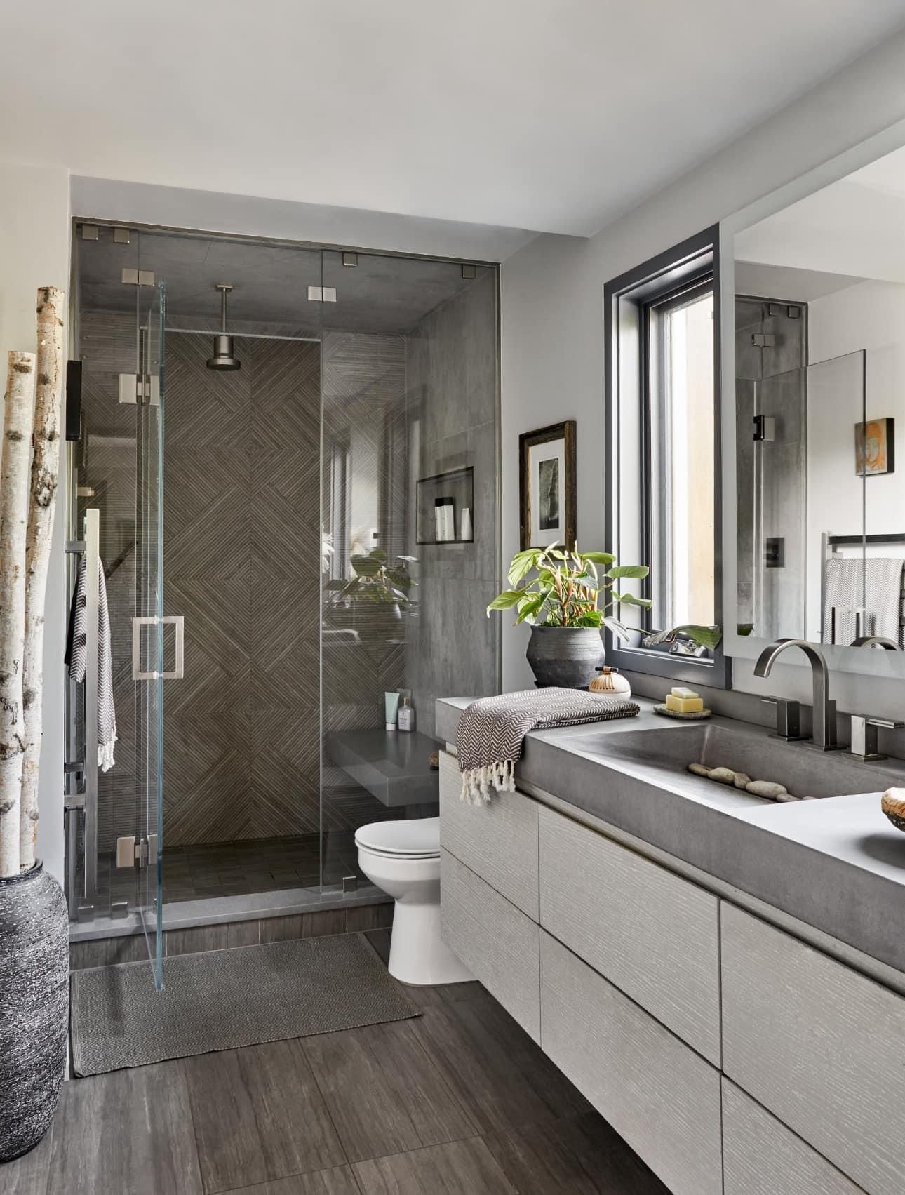 A bathroom with two sinks , a toilet , and a walk in shower.