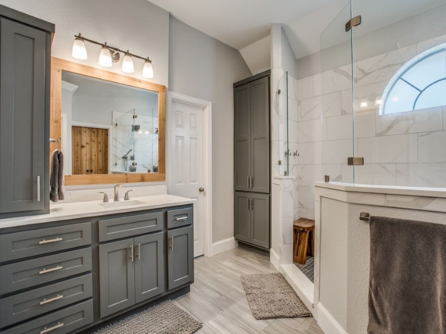 A bathroom with two sinks , a shower , and a large mirror.