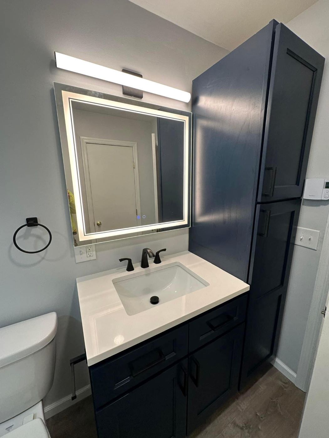 A bathroom with a sink , toilet and mirror.