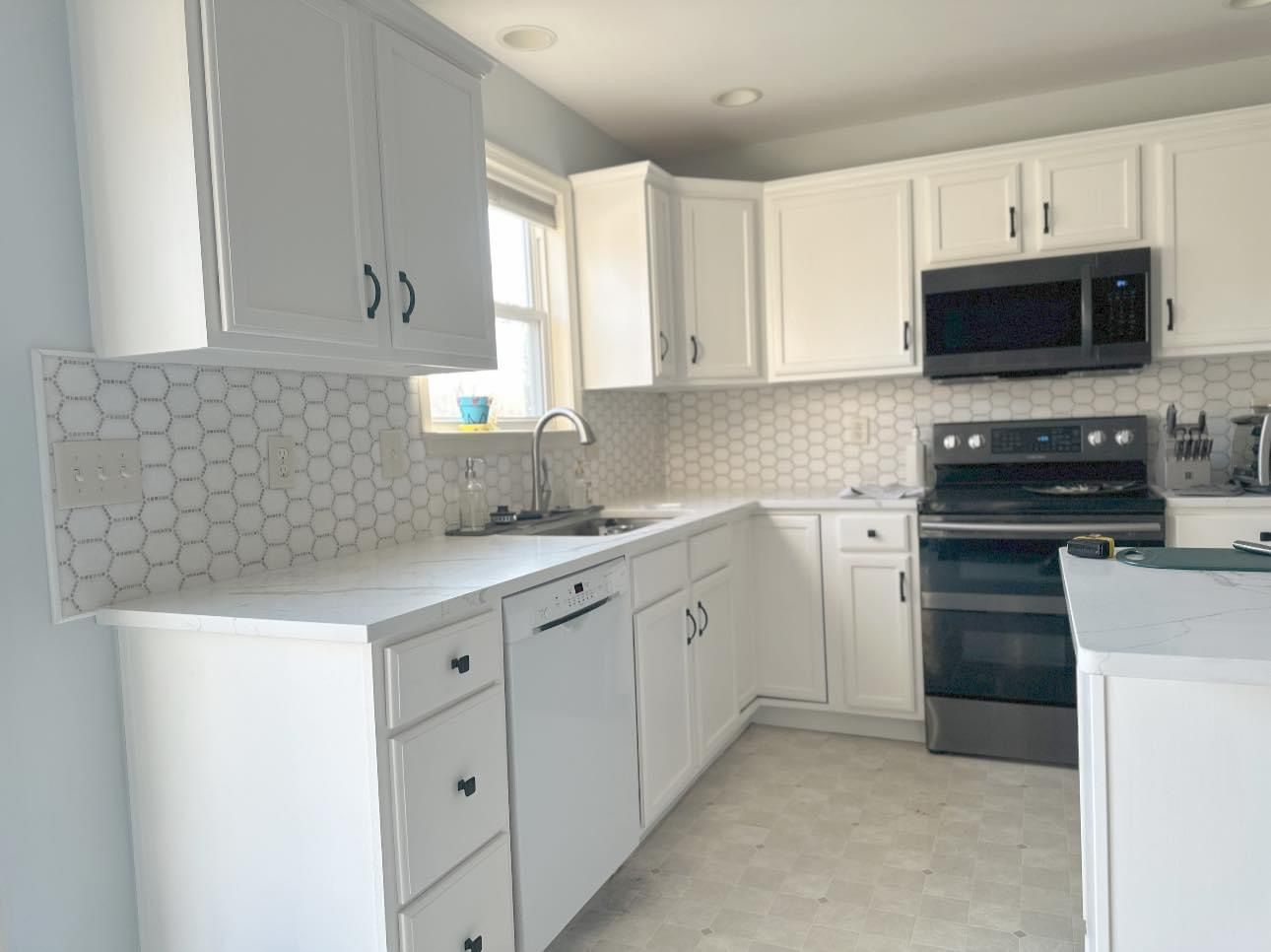 A kitchen with white cabinets and stainless steel appliances