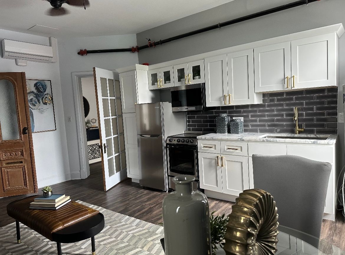 A kitchen with white cabinets, stainless steel appliances, a refrigerator, and a stove.
