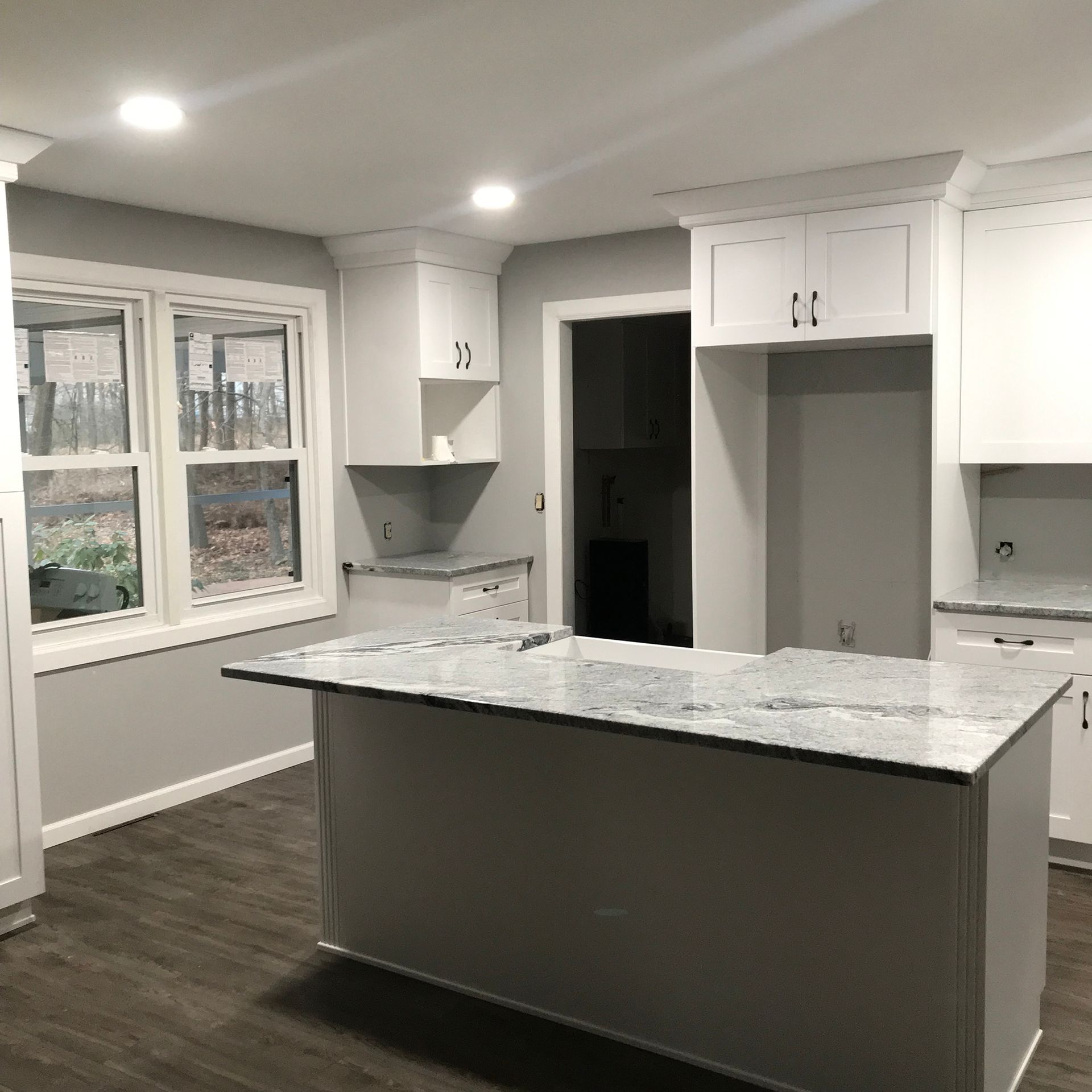 A kitchen with a large island and white cabinets