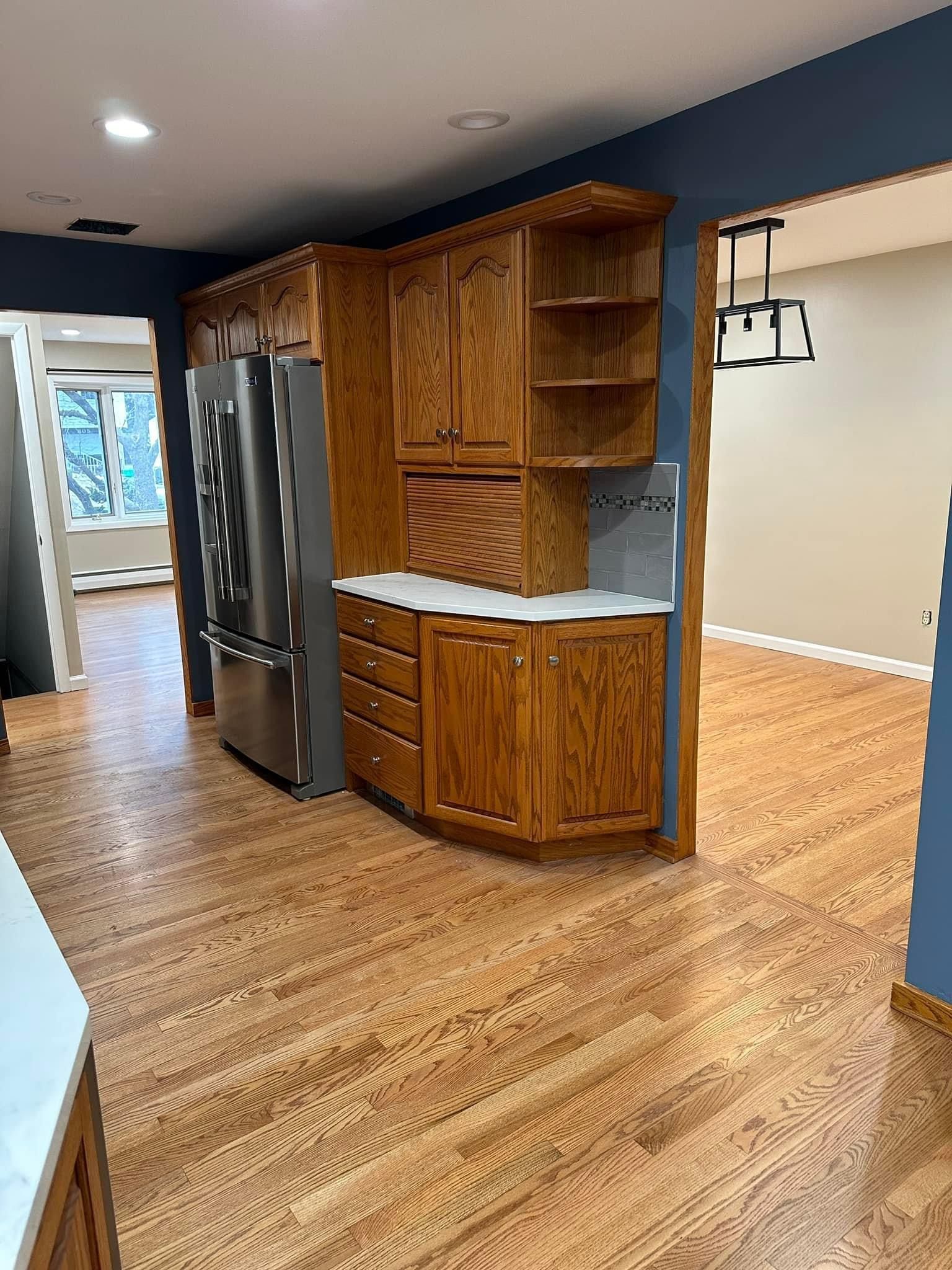 A kitchen with hardwood floors and stainless steel appliances.