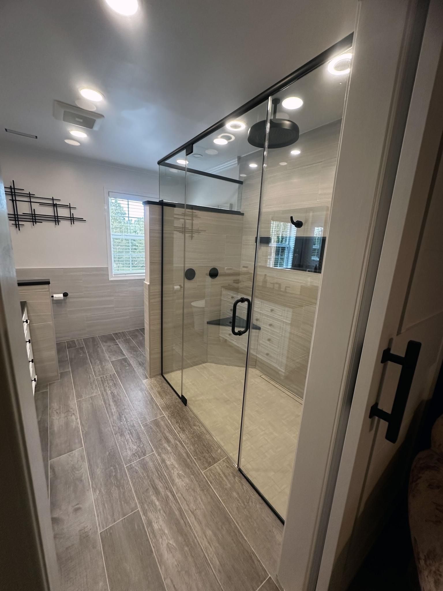A bathroom with a walk in shower and a window.