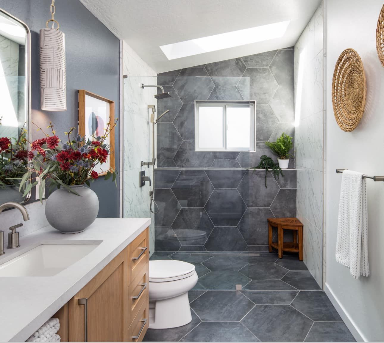 A bathroom with a toilet , sink , mirror and shower.
