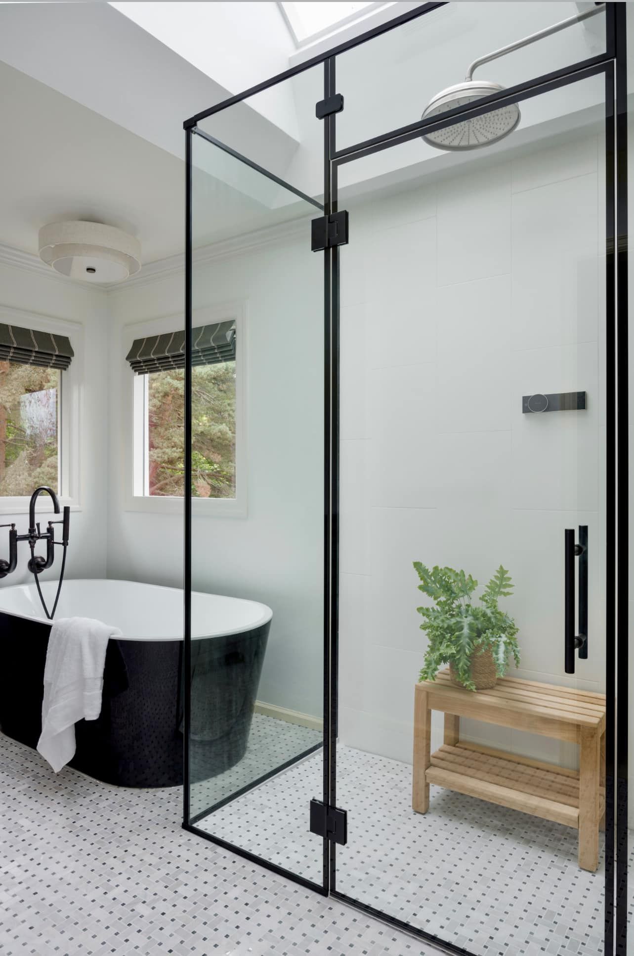 A bathroom with a black tub and a walk in shower.