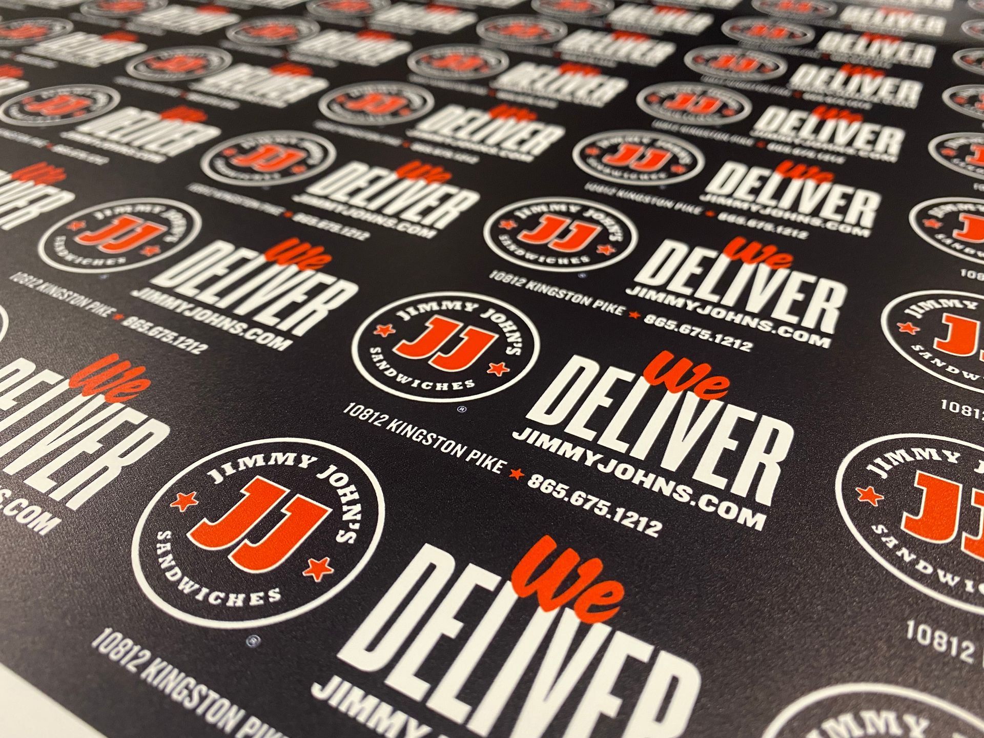 Sheet of black paper printed with the Jimmy John's logo, repeating text