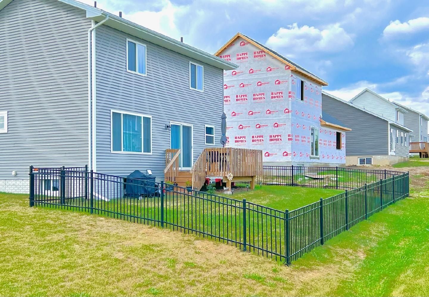 A house under construction with a fence in front of it.