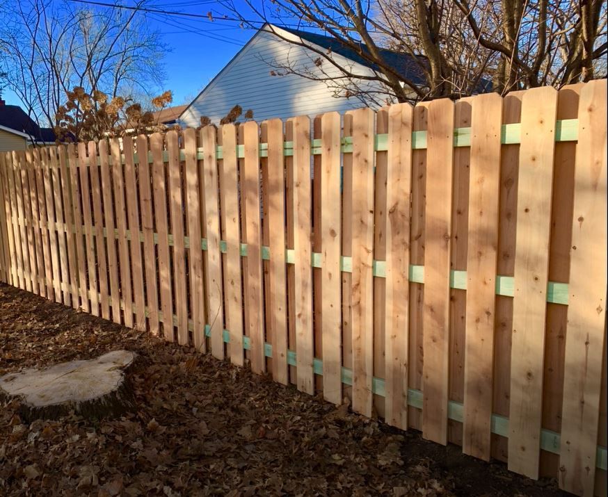 A wooden fence is sitting in front of a house.