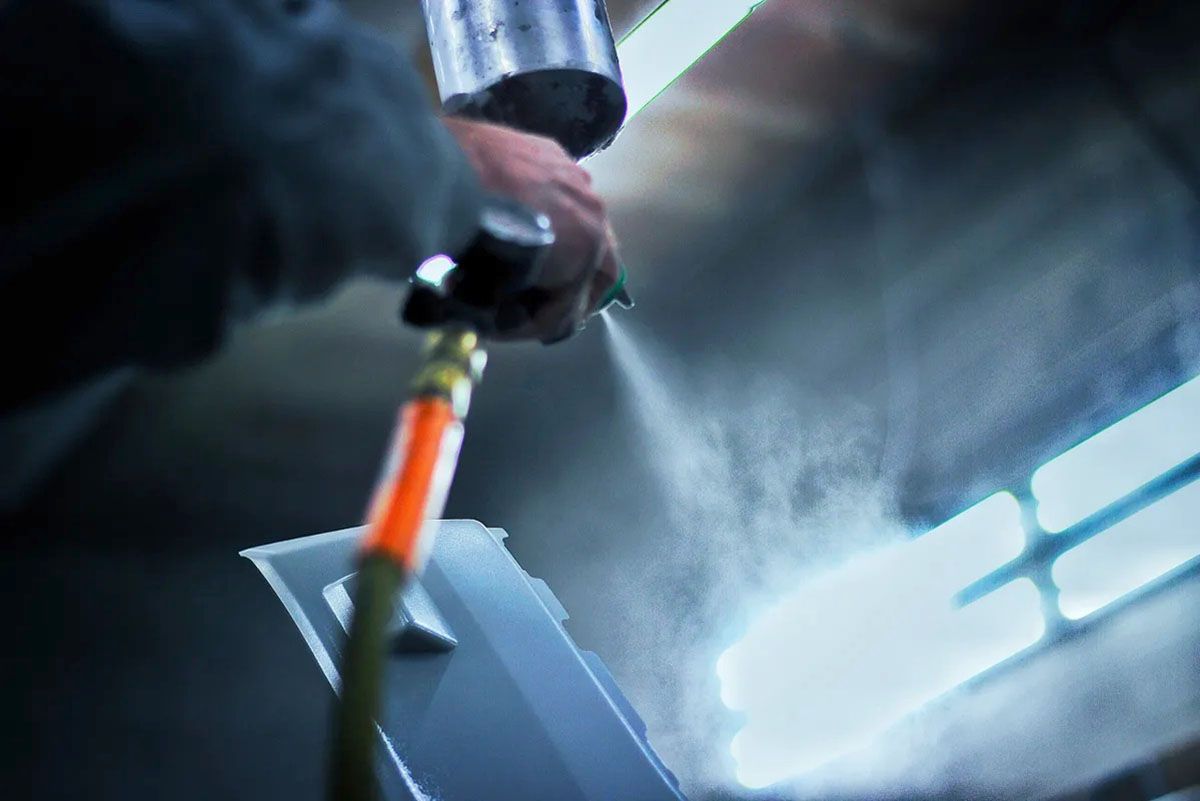 A person is spray painting a car