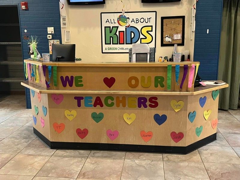 A wooden desk with hearts and the words `` we love our teachers '' on it.