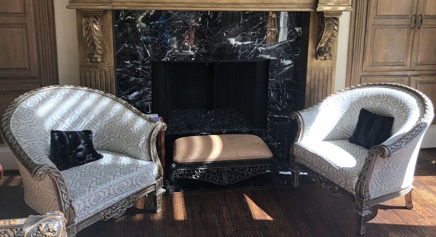 A living room with two chairs and a fireplace.