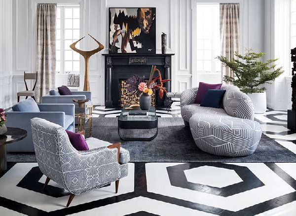 A living room with a couch, chairs, coffee table and fireplace.