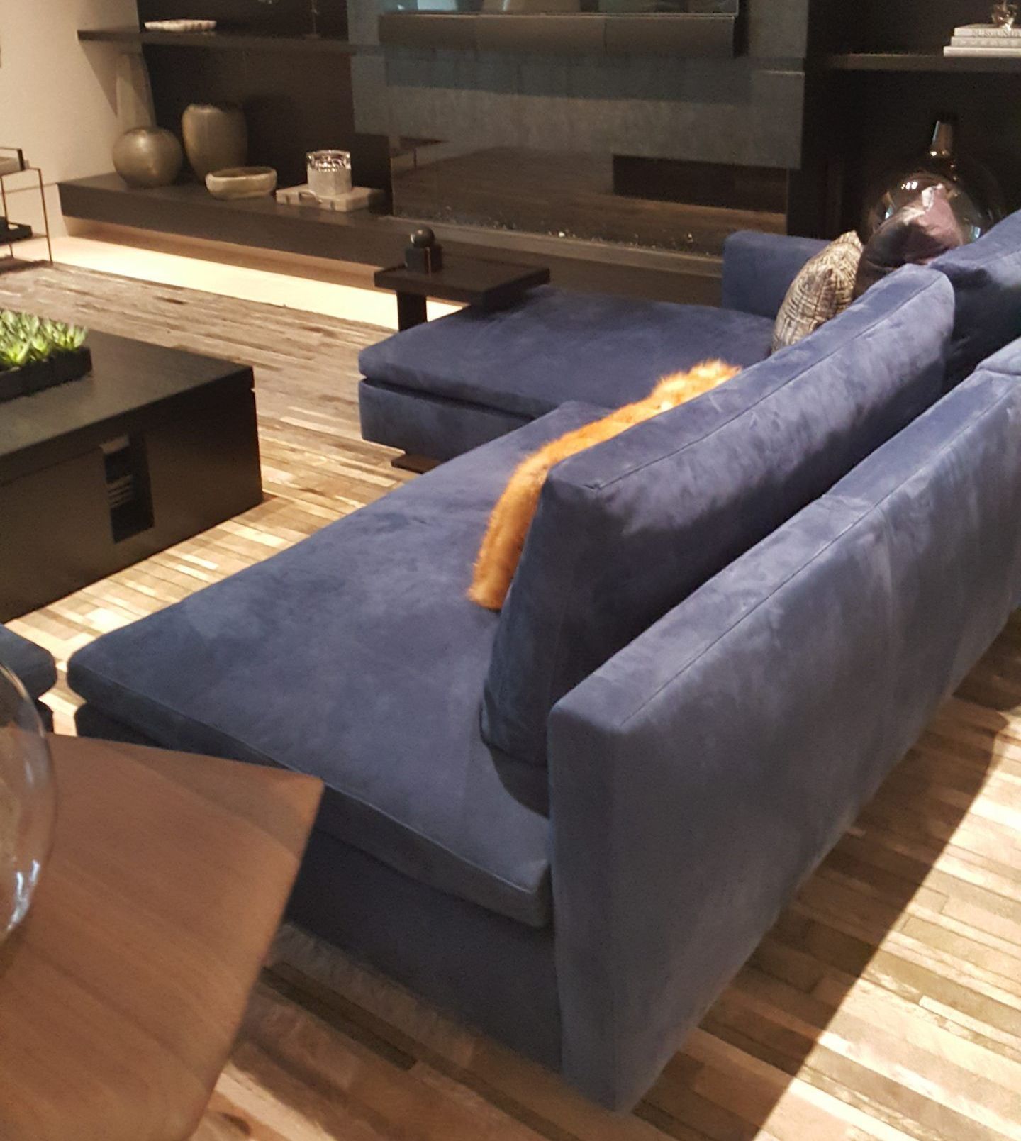 A living room with a blue couch and a flat screen tv.