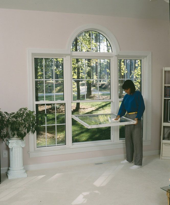 A person is standing in front of a large window
