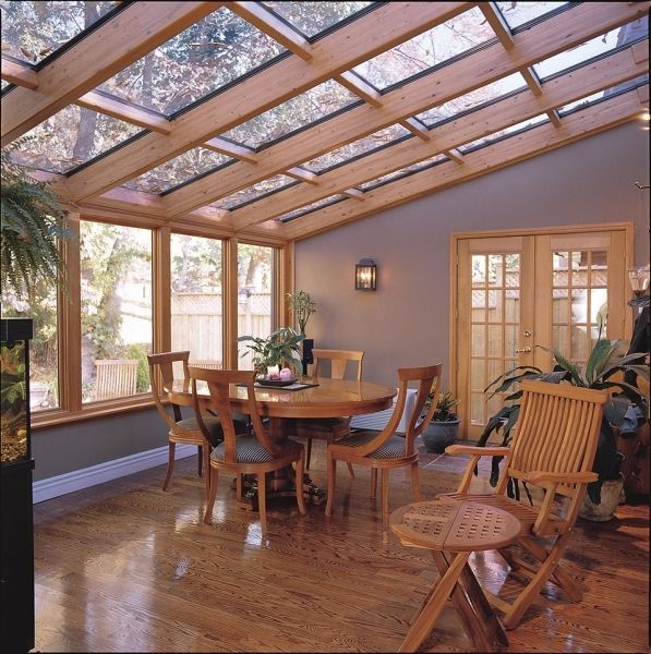 A dining room with a table and chairs under a glass roof