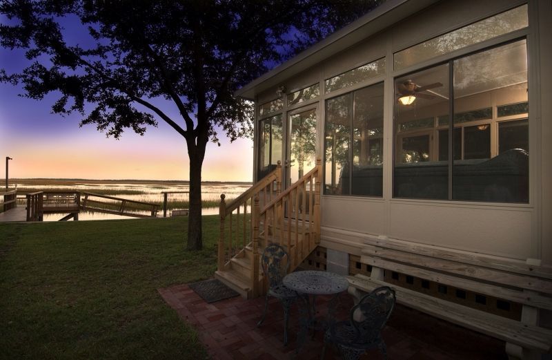 A screened in porch with a table and chairs