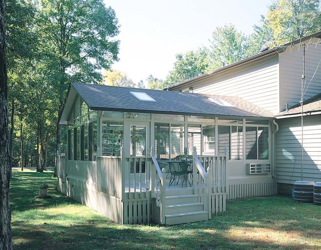 A house with a screened in porch surrounded by trees