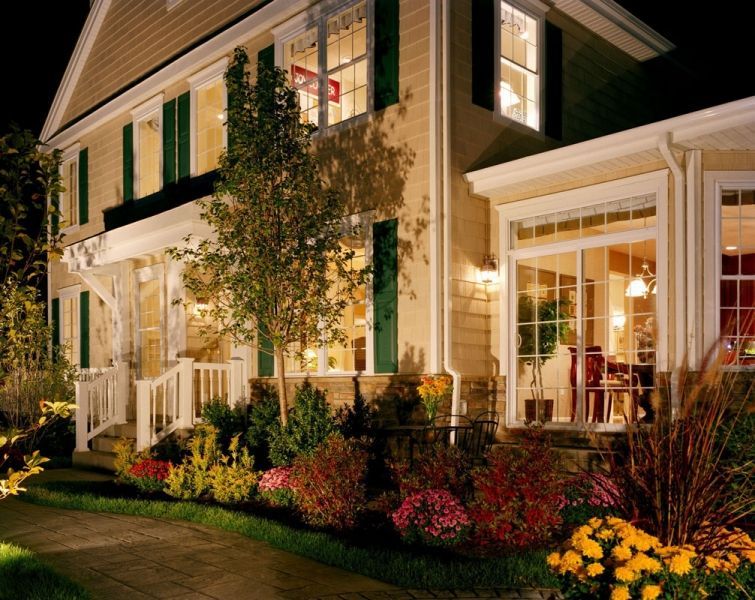 A house with green shutters is lit up at night