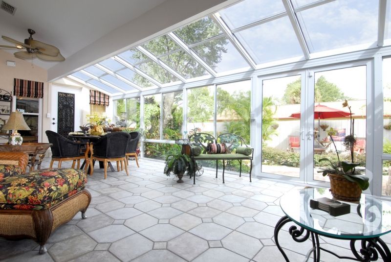 A living room with a lot of windows and a glass table.