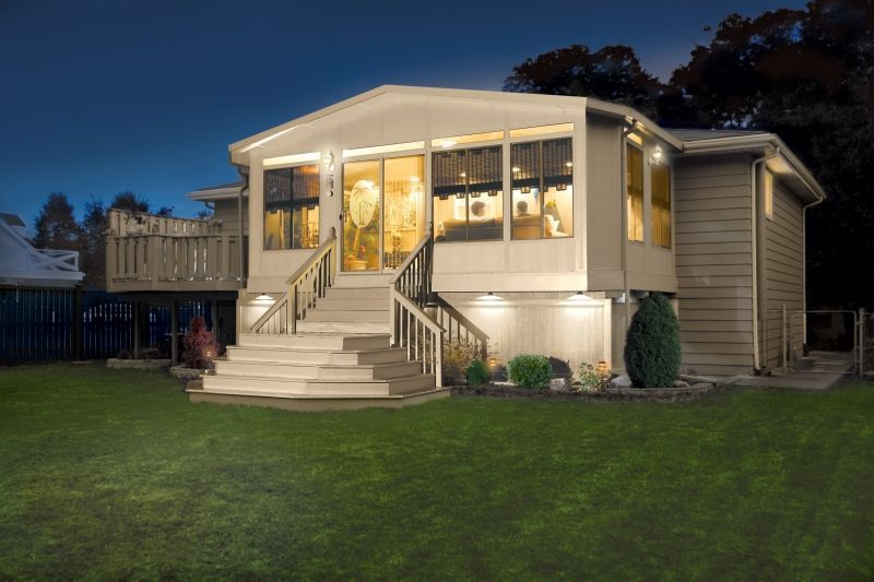 A house with stairs leading up to it is lit up at night.