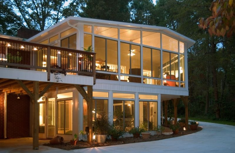 A large house with a lot of windows is lit up at night