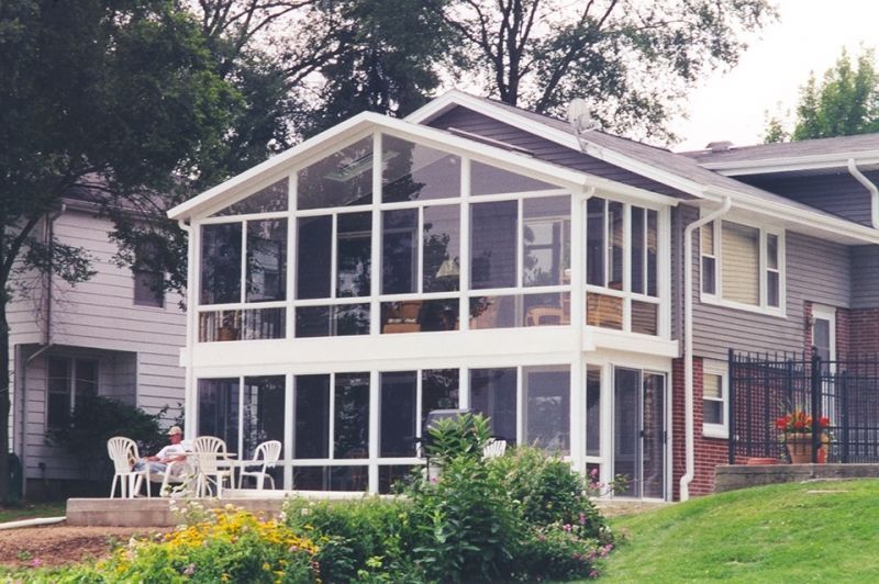 A house with a screened in porch and a table and chairs